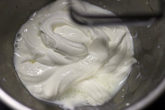 Chilled thick fresh cream added to a mixing bowl for strawberry mousse recipe