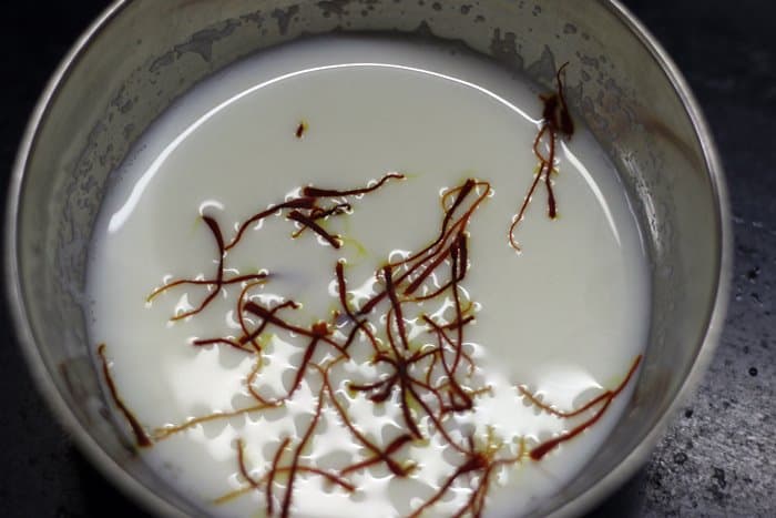 saffron strands soaked in warm milk for making sweet lassi
