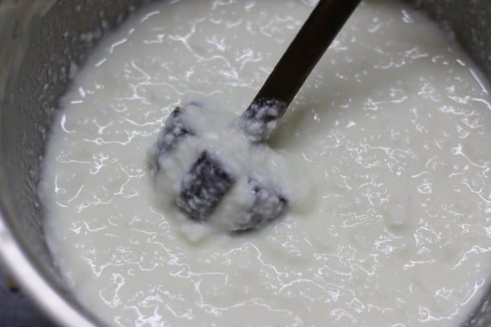 curd is whisked with a traditional Indian wooden churner for making lassi