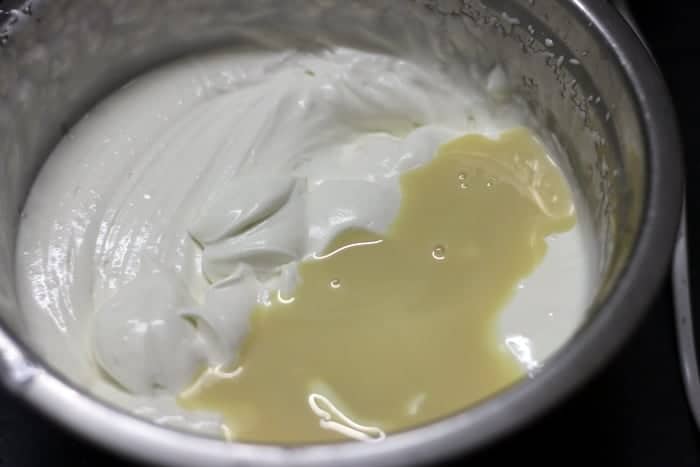 Condensed milk added to whipped fresh cream for tender coconut ice cream