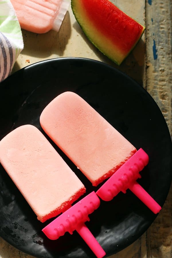 creamy watermelon popsicles served on ablack plate for dessert