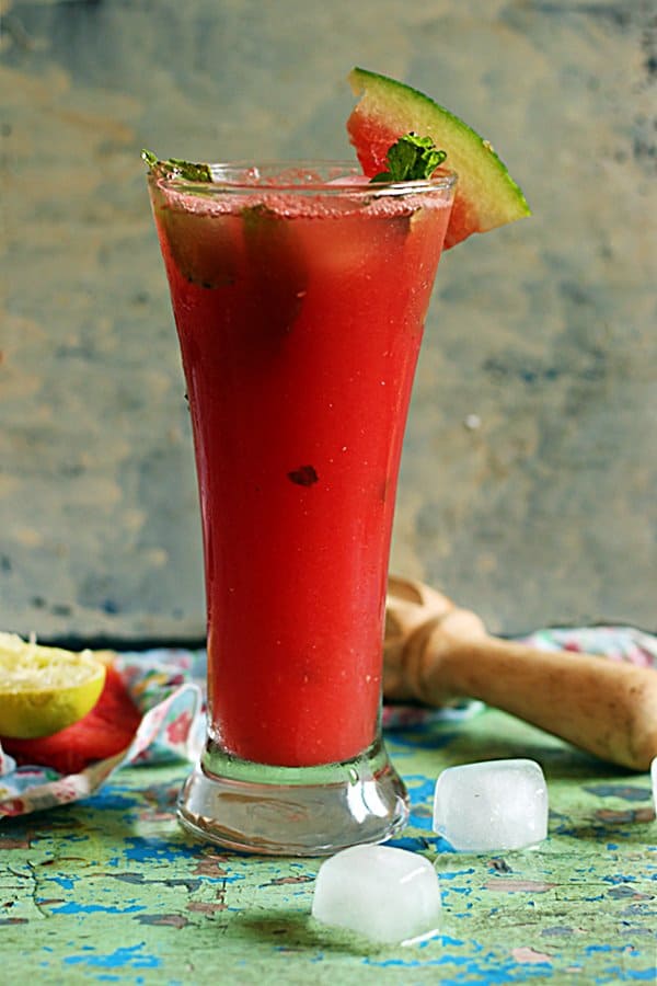 A tall glass of chilled watermelon agua fresca served with ice cubes