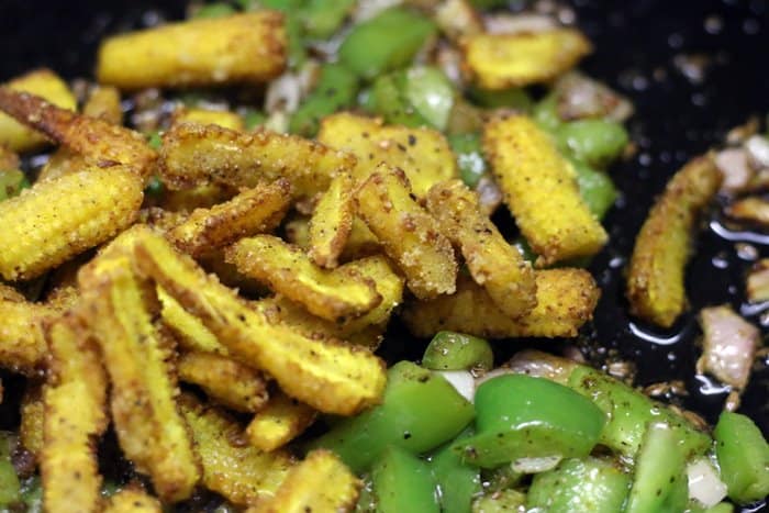 Fried baby corns added to sauteed peppers