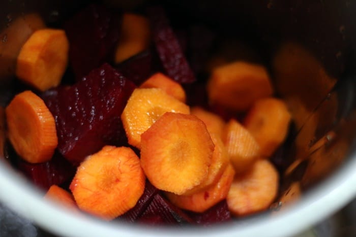 chopped beets and carrots in a blender jar