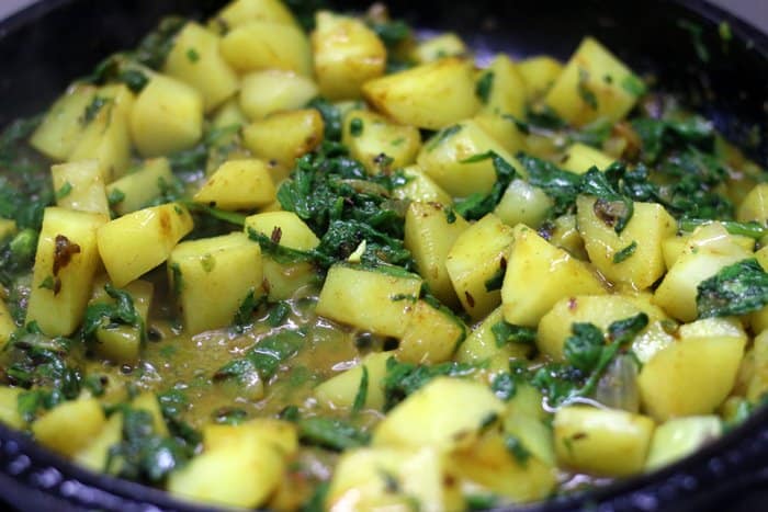 Making aloo palak curry