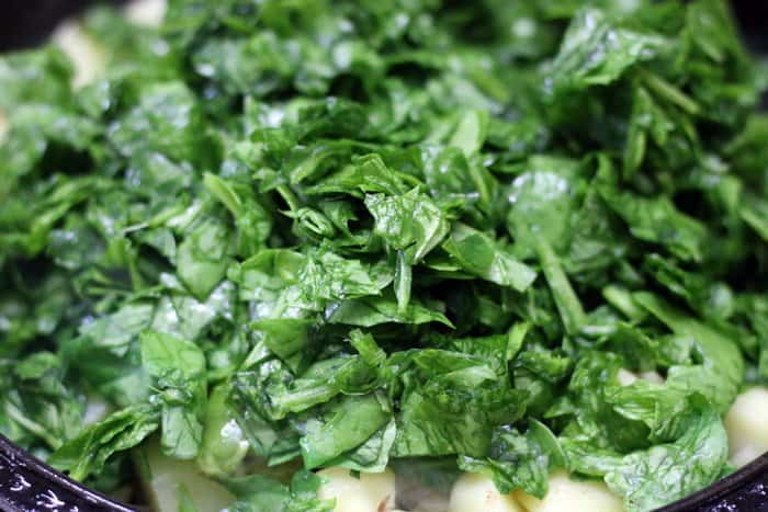 Finely chopped spinach leaves added to sautéed potatoes