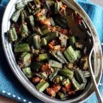 restaurant style bhindi masala served in a steel plate with a spoon