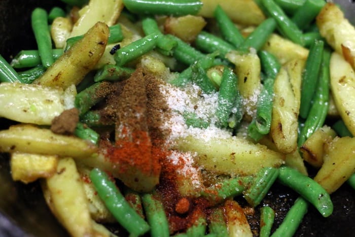 Chopped green beans and spice powders added