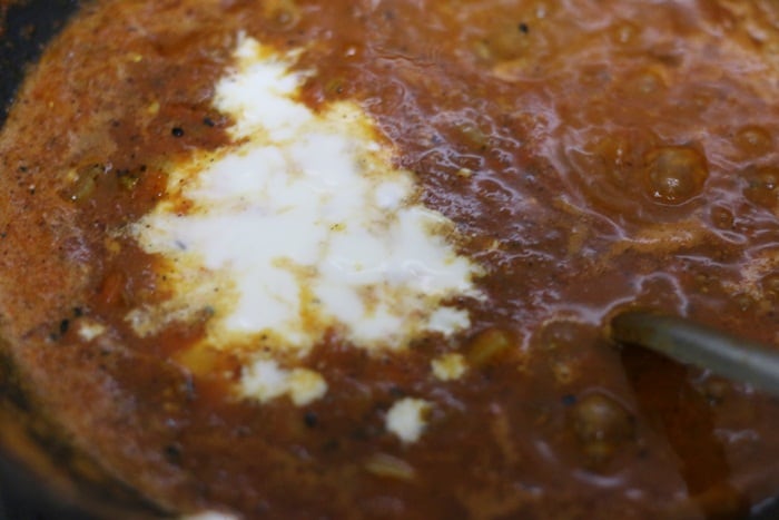 yogurt or curd added to onion tomato masala for achari paneer recipe