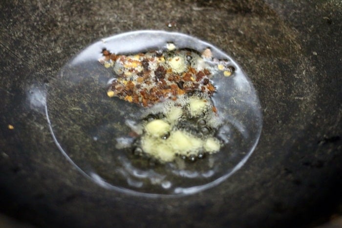 frying ginger garlic and chili flakes in sesame oil