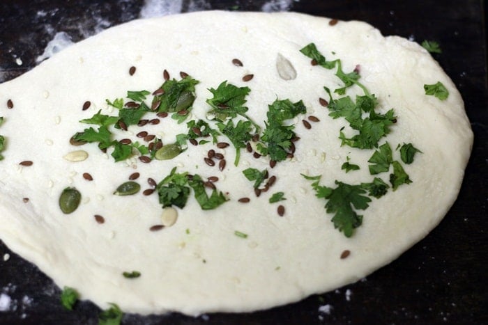 Toppings added to rolled and shaped dough