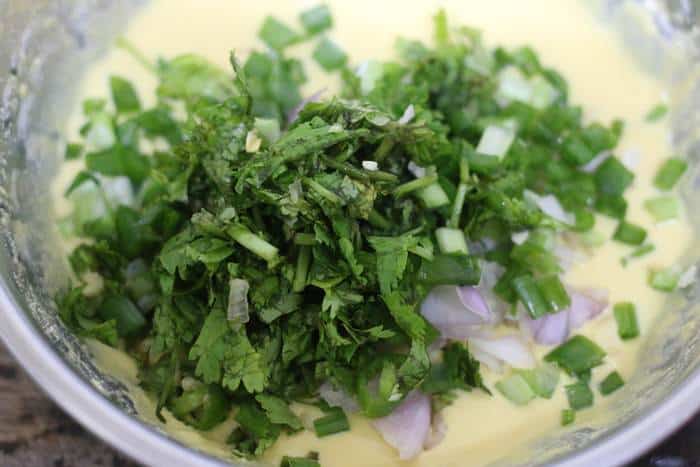 onions and chopped herbs added to chickpea slurry