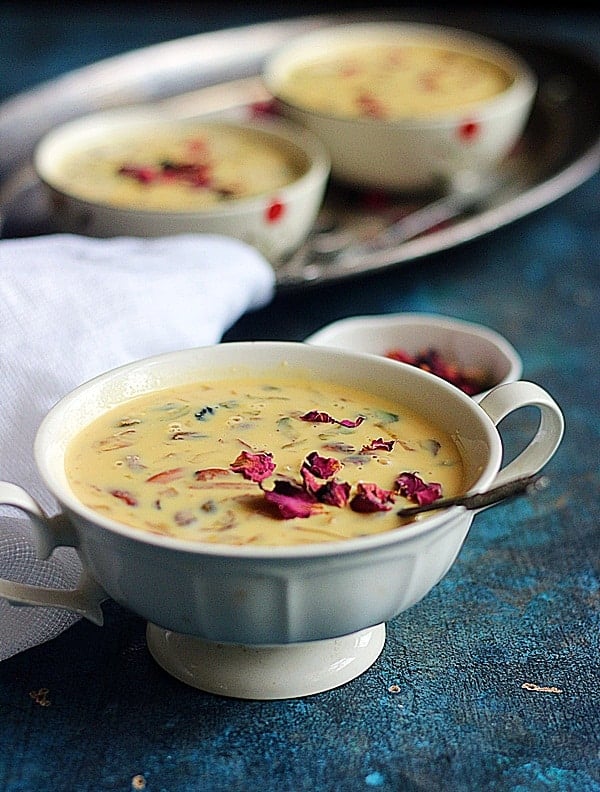 chilled basundi in a white ceramic bowl with spoon