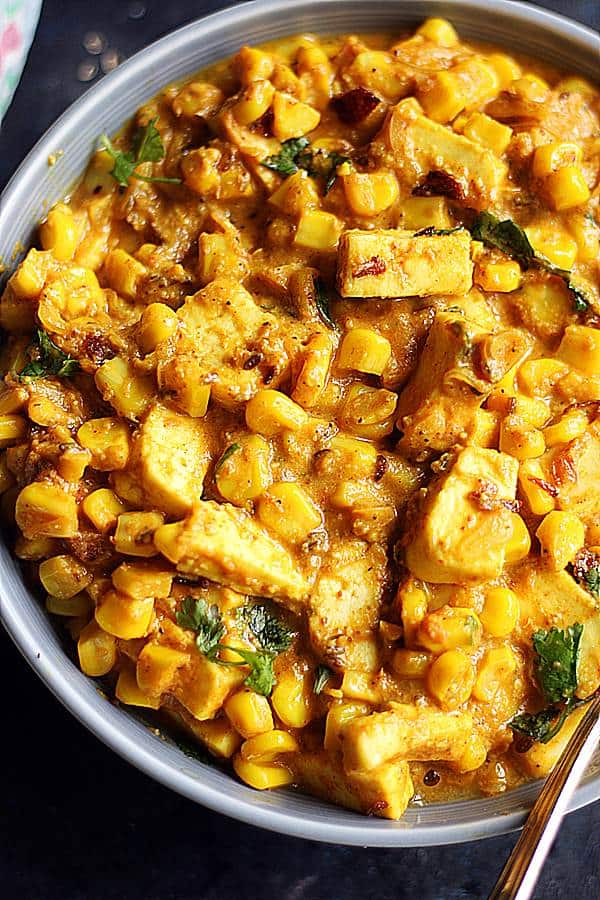 tofu curry with corn served in a grey bowl