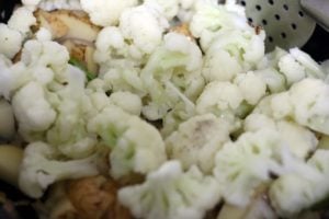 cauliflower florets added to potatoes