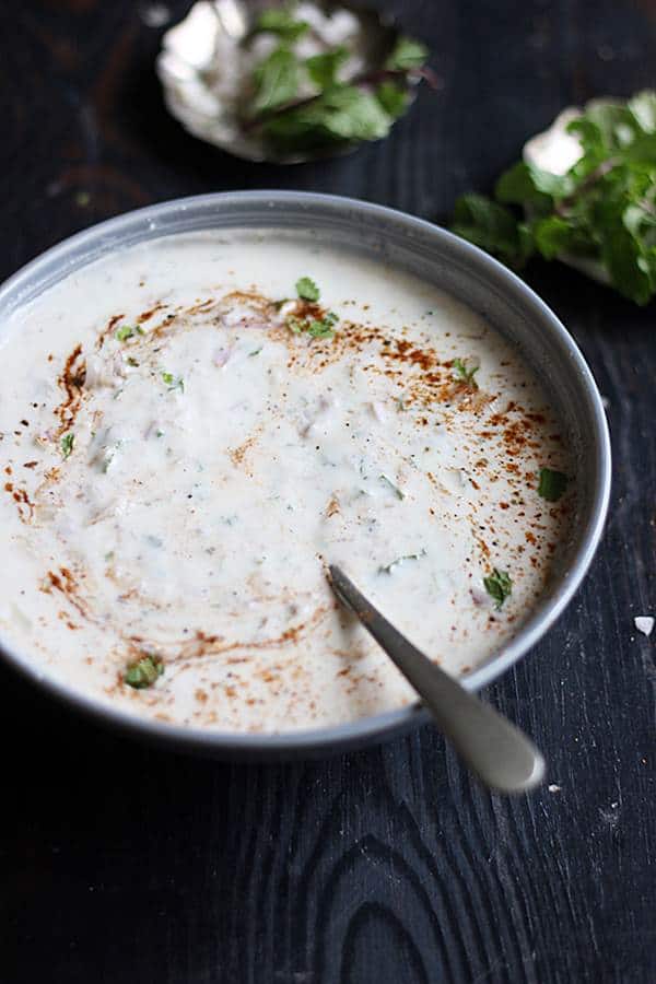 onion raita for biryani in a ceramic bowl