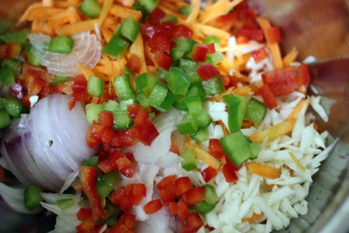 chopped carrot, cabbage, onion, capsicum placed in a bowl.