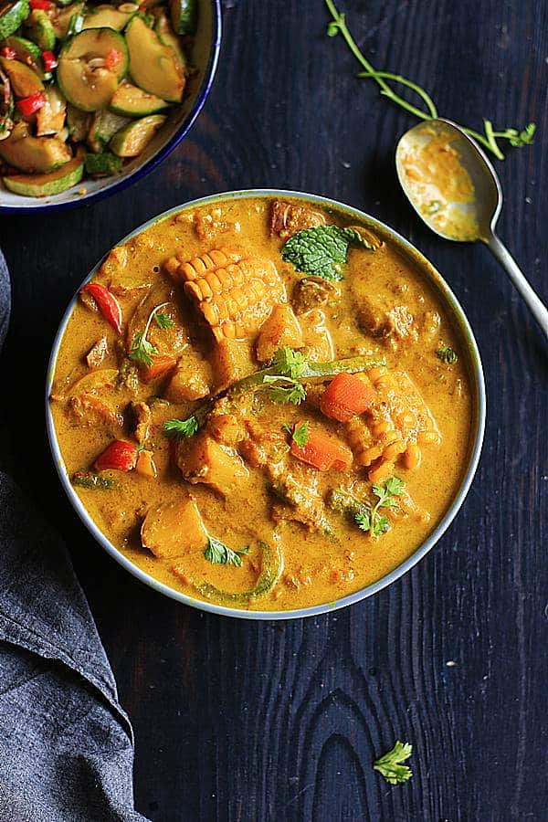 vegan thai yellow curry in a grey bowl with spoon