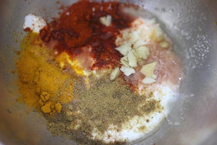 spice powders added to cashew yogurt in a mixing bowl