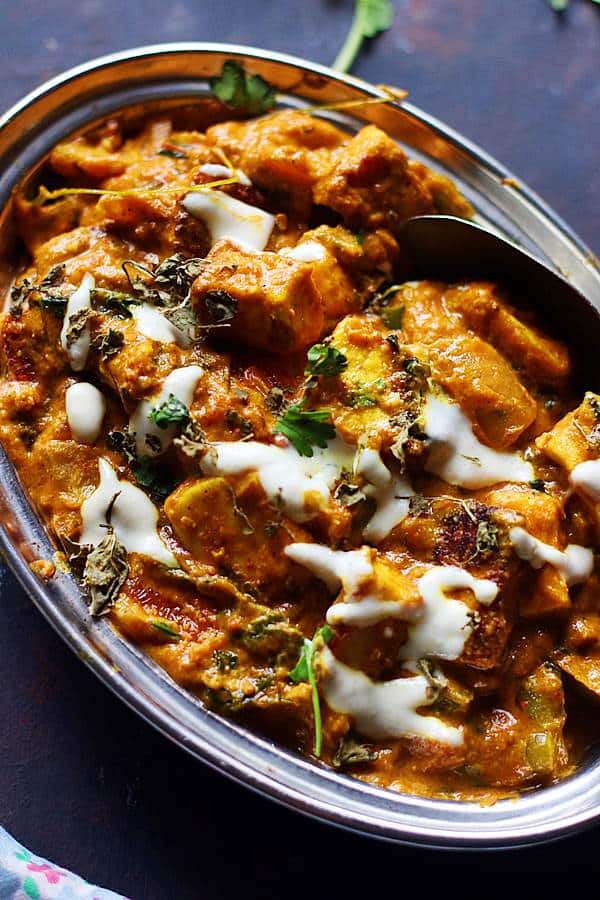 homemade tofu tikka masala curry served in steel plate with a spoon