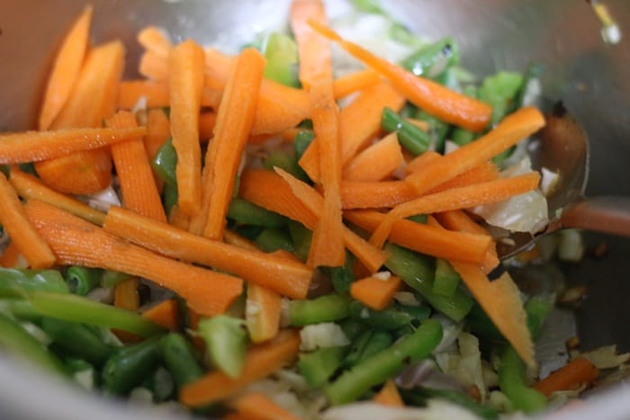 Stir frying carrots, peppers and beans