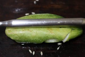 smashing the cucumber with a rolling pin