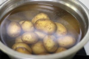 boiling tiny potatoes in hot water with salt.