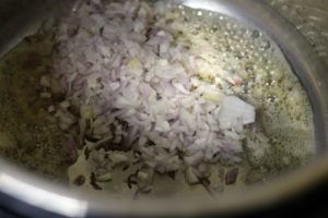 finely chopped onions sauteing in oil for making chole recipe