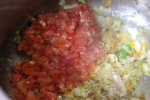 finely chopped tomatoes added to chopped onions for making punjabi chana masala