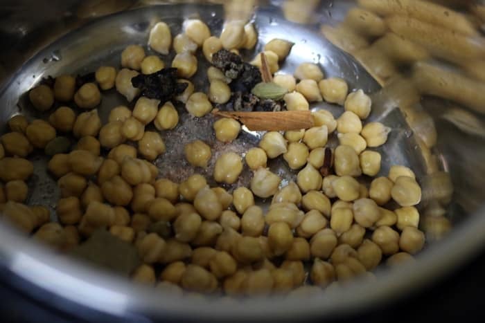 Whole spices added to chickpeas for making punjabi chole recipe