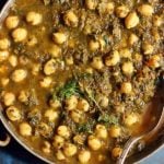 easy vegan chana saag served in a copper kadai with a spoon.