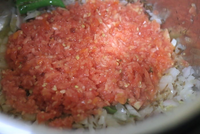 chopped tomatoes added to sauteed onions for making saag chana