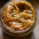 closeup shot of roasted tomato salsa in a glass jar.