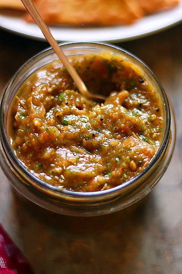 closeup shot of roasted tomato salsa in a glass jar.