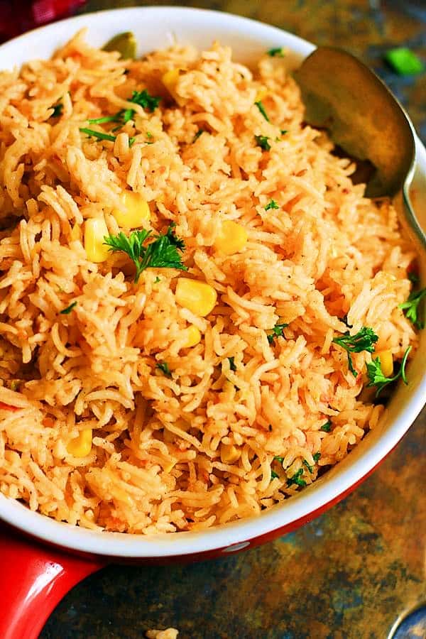 easy vegan spanish rice served in a ceramic bowl with spoon.