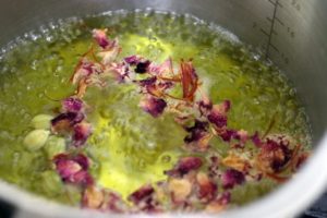 boiling saffron, spices and rose buds in water