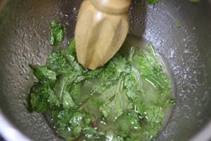 muddling simple syrup with mint leaves