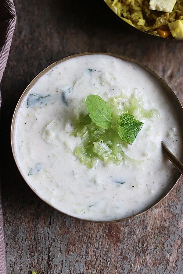 refreshing and creamy cucumber raita served in a copper bowl