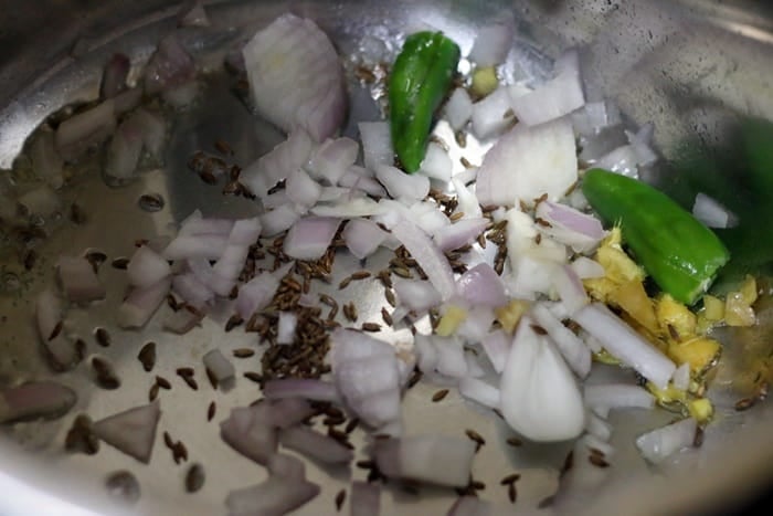 sautéing onions and cumin seeds, green chillies and ginger in oil