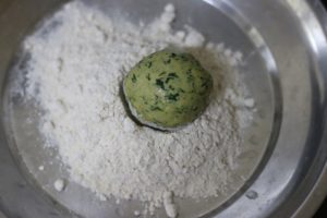 dusting a dough ball with dry flour for rolling