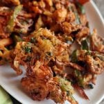 crispy mixed vegetable pakora served in a ceramic white plate