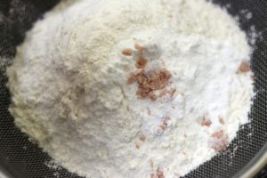 sifting flour, baking powder,, corn flour & baking soda over dry ingredients