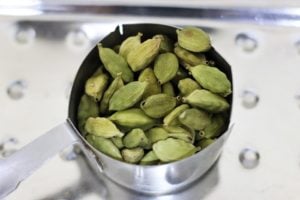cleaned green cardamom pods in a measuring cup