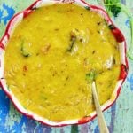 masoor dal or red lentils curry served in a ceramic bowl with a spoon