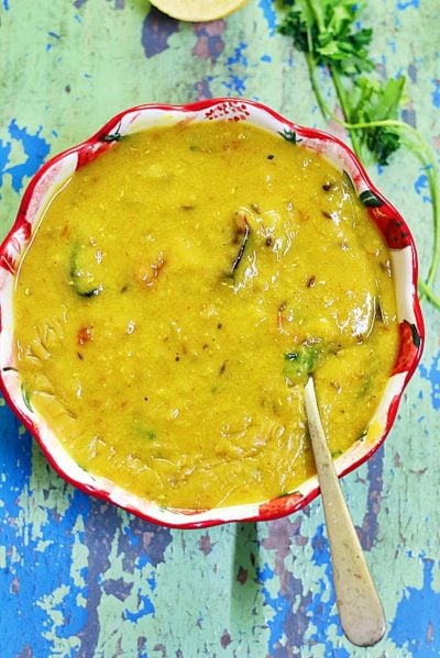 masoor dal or red lentils curry served in a ceramic bowl with a spoon