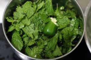 Mint leaves, greem chilies and ginger in a mixer jar